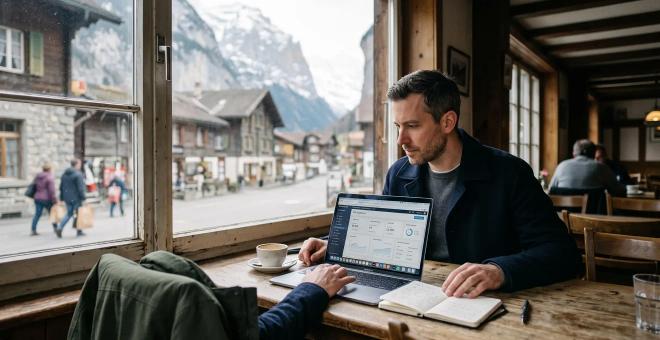 Eine Mitarbeiterin arbeitet in einem Café am Laptop mit geöffnetem Browserzugriff auf die zentrale Unternehmenssoftware, im Hintergrund ein Schweizer Dorf.